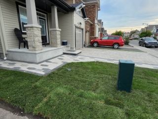 Modern front entryway with high-quality stone pavers, integrated lighting, and a welcoming porch design.