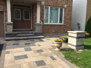 Modern front entrance with interlock driveway and walkway, featuring a sleek mix of light and dark pavers