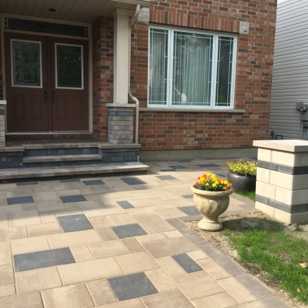 Modern front entrance with interlock driveway and walkway, featuring a sleek mix of light and dark pavers