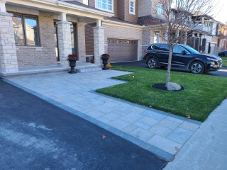 New front entrance walkway with premium stone pavers for a polished and welcoming look.