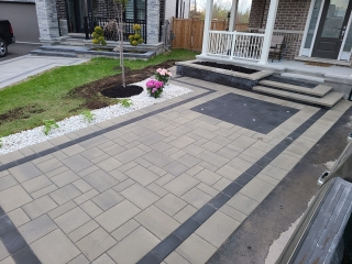 Modern front entrance with interlock driveway and walkway, featuring a sleek mix of light and dark pavers.