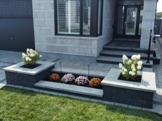 Freshly installed interlock front entrance with a modern paver design and step detailing.