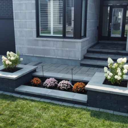 Freshly installed interlock front entrance with a modern paver design and step detailing.