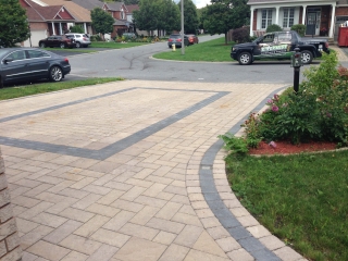 Brand new interlock driveway with modern stone pavers arranged in a herringbone pattern.