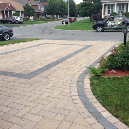 Brand new interlock driveway with modern stone pavers arranged in a herringbone pattern.