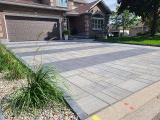 Newly Installed: &quot;Brand new interlock driveway with modern stone pavers arranged in a random pattern.