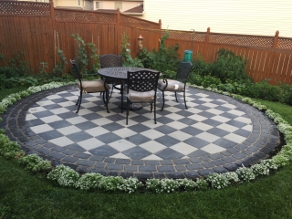 Custom-designed interlocking stone patio with a bold border accent and integrated step features.