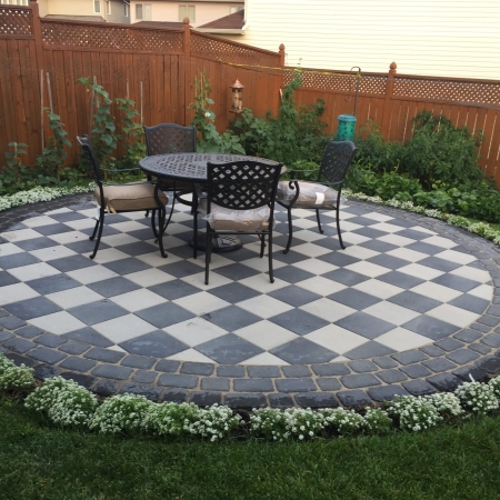 Custom-designed interlocking stone patio with a bold border accent and integrated step features.