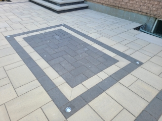 Modern backyard patio with interlock pavers and design and LED lights