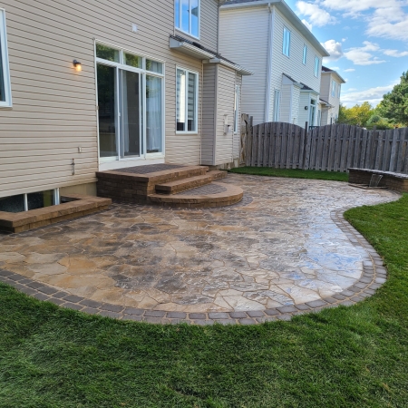 Spacious outdoor living area featuring a custom curved patio, built-in seating, and seamless transition to the lawn.
