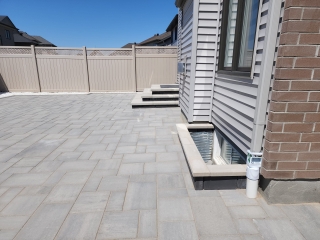 Modern backyard interlock patio with contrasting border design