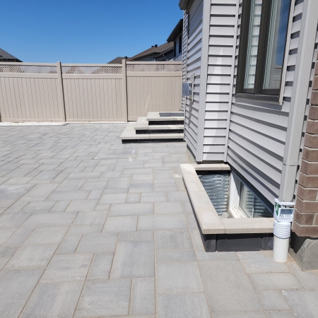 Modern backyard interlock patio with contrasting border design