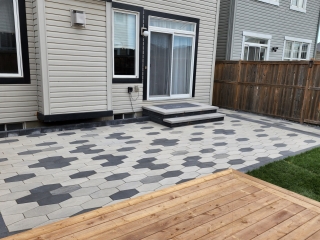 Newly installed hardscape patio with a geometric pattern, perfect for outdoor entertaining.