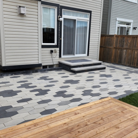 Newly installed hardscape patio with a geometric pattern, perfect for outdoor entertaining.