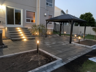 Custom-designed interlocking stone patio with a bold border accent and integrated step features.