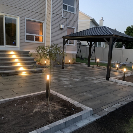 Custom-designed interlocking stone patio with a bold border accent and integrated step features.