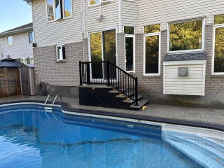 Custom poolside hardscape with durable stone pavers, perfect for summer relaxation