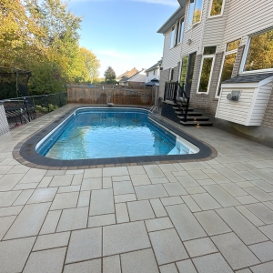 Custom poolside hardscape with durable stone pavers, perfect for summer relaxation