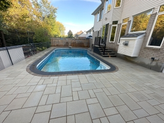 Custom poolside hardscape with durable stone pavers, perfect for summer relaxation